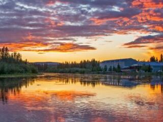 Sunset over lake with colorful sky.