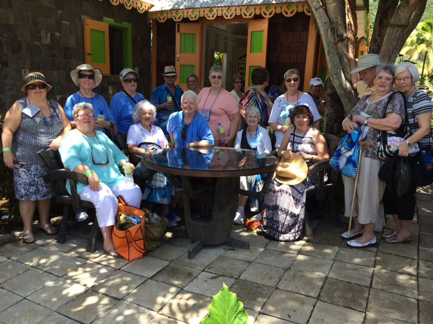 Group of people posing outdoors by table.