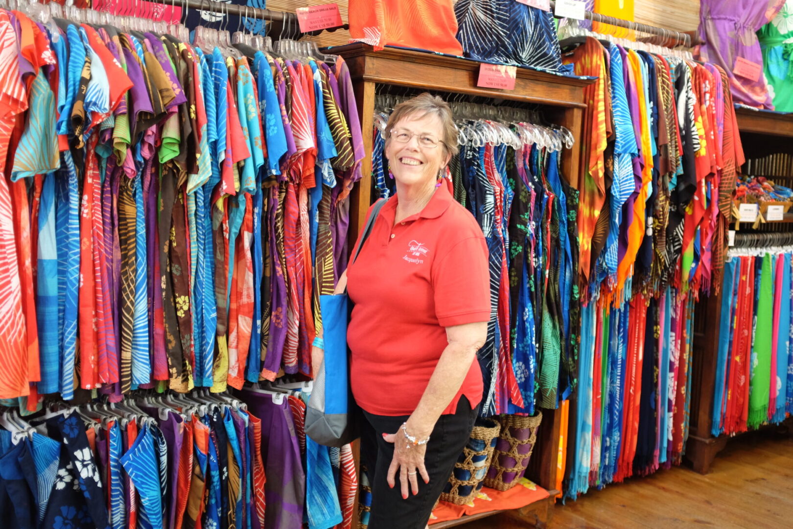 Woman smiling in colorful clothing store.