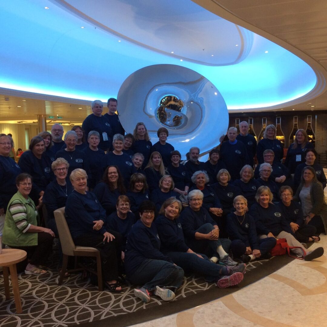 Group posing in front of large sculpture.