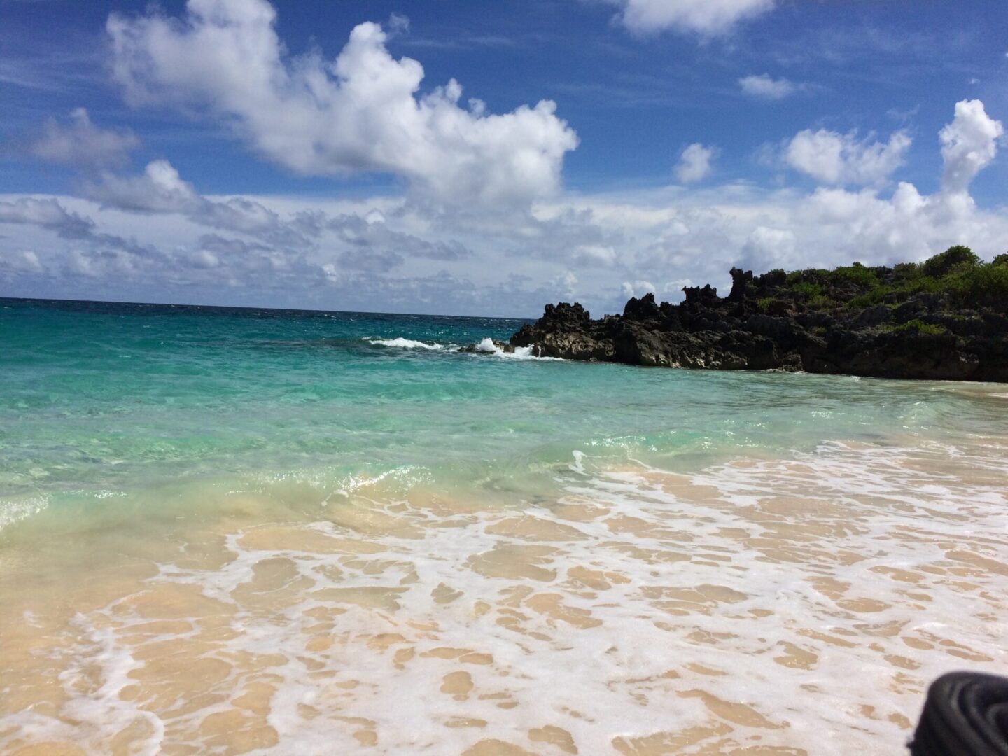 Tropical beach with turquoise water and rocks.