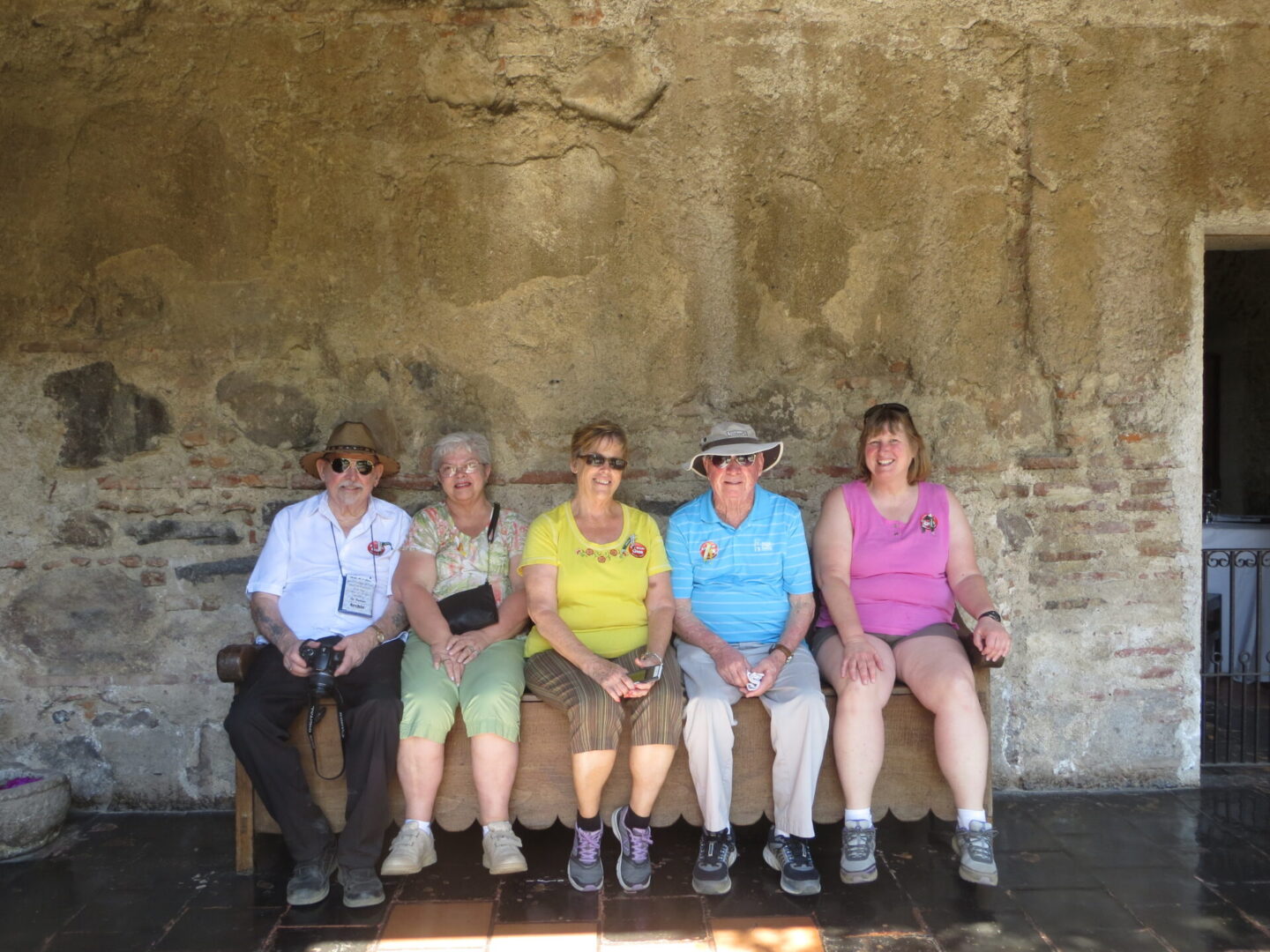 Five people sitting on a wooden bench.