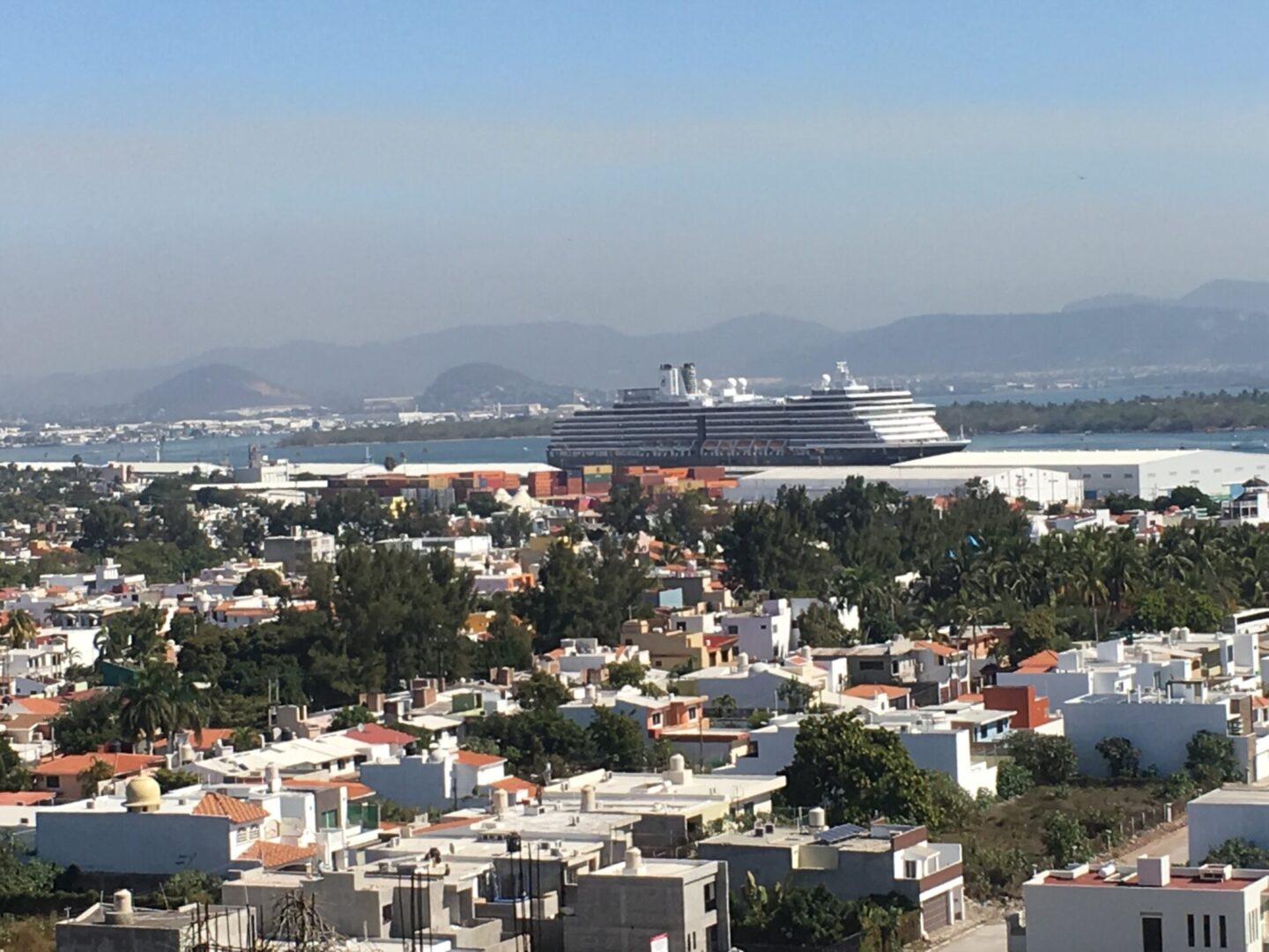 Cruise ship near coastal city landscape.
