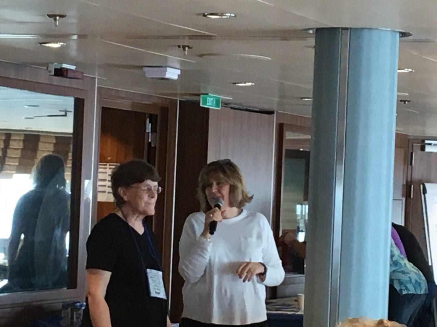 Two people speaking indoors with microphone.