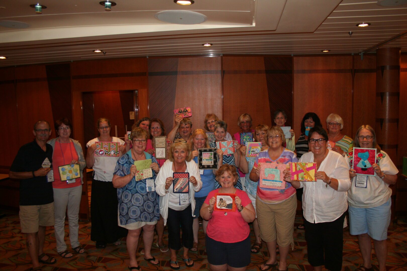 Group holding colorful handmade crafts indoors.