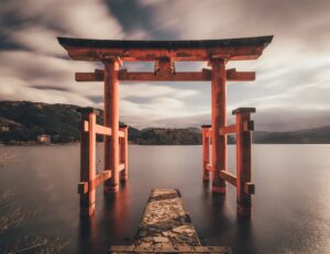 Japanese torii gate over calm water.