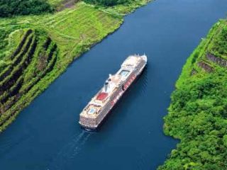 Cruise ship sailing through narrow canal.